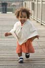 Adorable baby girl running on boardwalk
